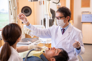 Obraz premium 治療する歯科医師と歯科衛生士 