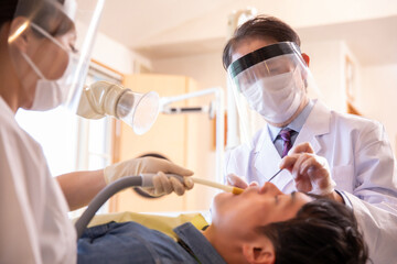 治療する歯科医師と歯科衛生士
 - obrazy, fototapety, plakaty