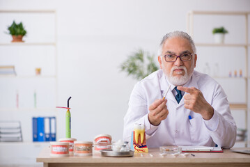 Old male doctor dentist working in the clinic