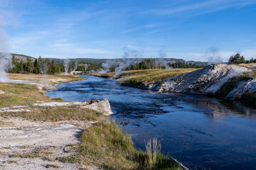 Geysers and thermal features steam along the banks of the Yellowstone River