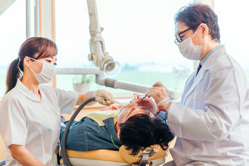 歯医者と歯科衛生士と男性患者
