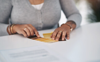 I quite like this colour here. Cropped shot of an unrecognizable businesswoman sitting alone in her office and looking at a colour swatch.