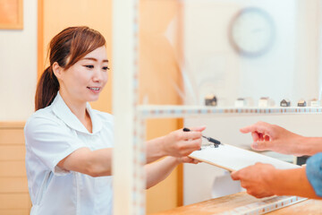 Fototapeta premium 受付パーテーションと医療スタッフ 