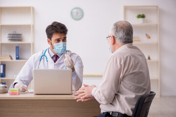 Fototapeta premium Old male patient visiting young male doctor in vaccination conce