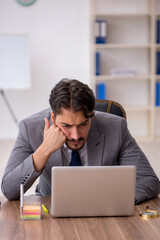 Young male employee sitting in the office