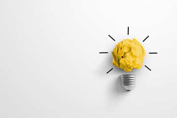 Creative thinking ideas and innovation concept. Paper scrap ball yellow colour with light bulb symbol on white background