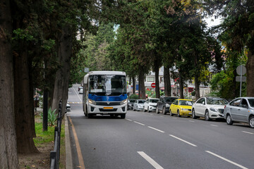 Naklejka na ściany i meble Automobile road with parked cars along the roadside.