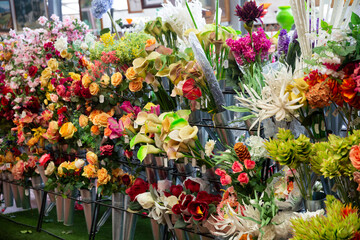 Colorful showcase of flower shop with large assortment of artificial flowers