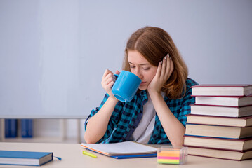 Young female student drinking coffee during break
