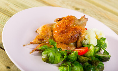 Delicious tobacco quail with pepper and aromatic herbs served on cushion of steamed vegetables