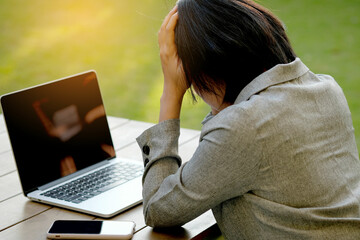 woman sitting down, his face unsettled. At the computer desk she has headaches and stress. Cause of...