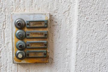 Close-up of an old metal plate on a house with bells