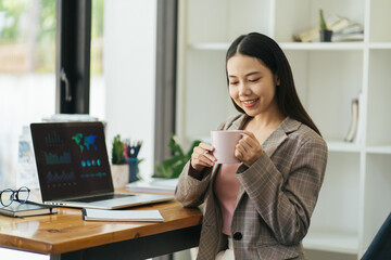 Benefits of remote work. Dreamy lady enjoying coffee during work on laptop computer in city cafe, smiling and looking aside. Young freelancer having break while working online in internet