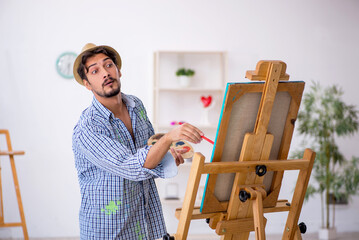 Young man enjoying painting at the studio