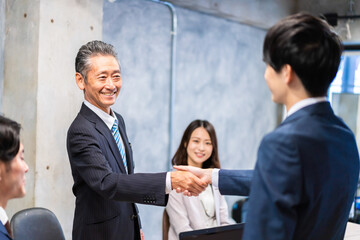 笑顔で握手をするビジネスパーソン