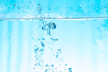 Air bubbles in fresh water with bright blue background. Sponges that regulate of foam with splash water and water level.