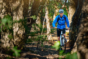 Obraz premium Forest fitness fanatic. Shot of a male cyclist riding along a mountain bike trail.