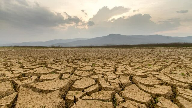 Climate Change, Landscape of Dry mud cracked earth on summer. River drying during season of rain. Lacking of fresh water. Timelapse