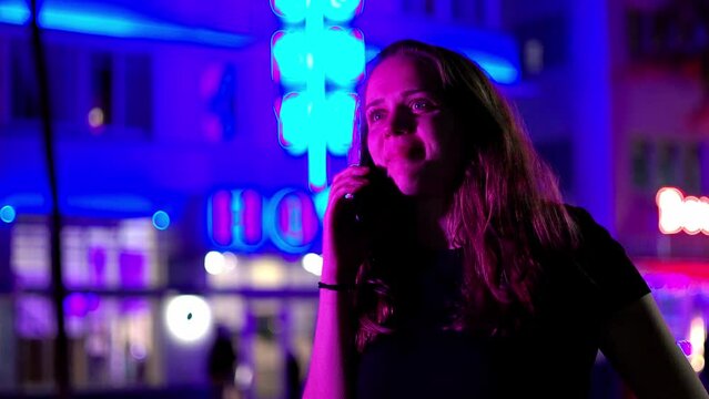 Colorful Ocean Drive at Miami Beach at night - Young woman takes a phone call under the neon lights - travel photography