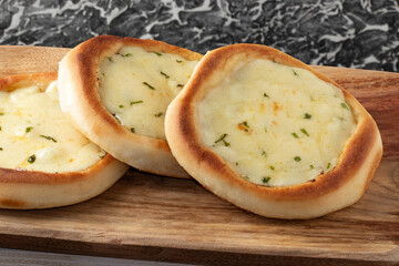 Cheese sfiha on cutting board.