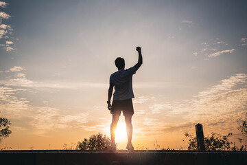 Confident men raise their hands in the air for success, victory and power. Sport man rise hand up on sunset sky background. Freedom and sport concept. - obrazy, fototapety, plakaty