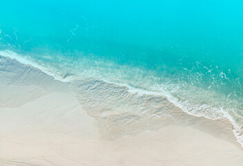 Aerial view of Soft wave with turquoise water of ocean on the sandy beach background