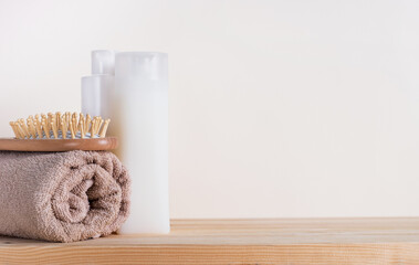 Obraz na płótnie Canvas Shampoo bottles, hair brush and cotton towels on white background. Bath accessories, hair care concept. Closeup, copy space