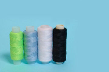 Coils with black, white, blue and green threads on a blue background