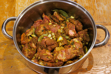 Preparing Jamaican goat curry - marinated in curry powder, onions, thyme, all spice and garlic