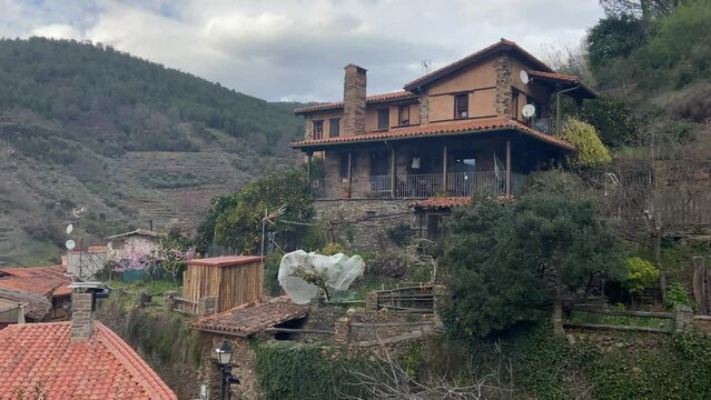 Panning wide of a large rural modern house for rent in a traditional historic village in deep Spain.