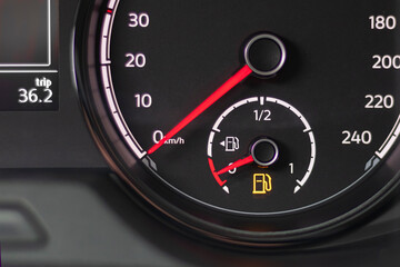 soft focus. natural light. the dashboard. it is lit, the fuel level arrow shows that it is empty, refueling is necessary. there is a tinting.