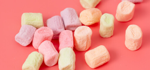 Multicolored candies on a pink background. Close-up