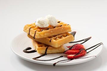 Delicious Plate Of Belgian Waffles With Chocolate Sauce And Ice Cream And Strawberries On White Plate On White Background