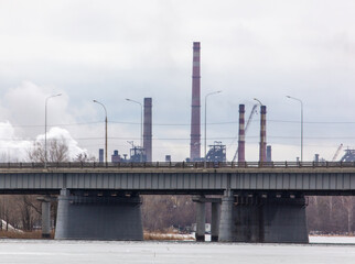 Obraz premium Concrete bridge against the background of the pipes of the plant.