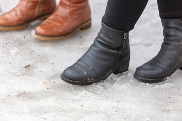 Women's legs in boots on the snow.