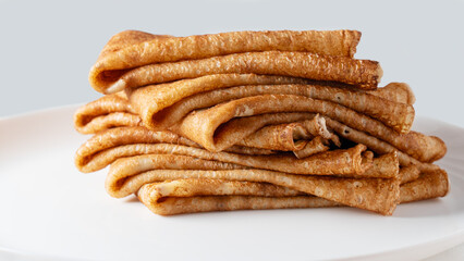 big high stack of thin pancakes in a plate