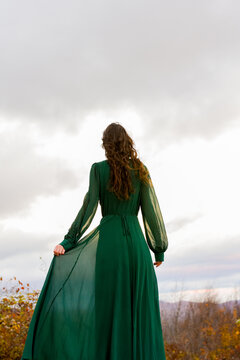 Woman In Long, Green, Flowy Dress Overlooking The Mountains 