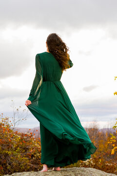 Woman In Long, Green, Flowy Dress Overlooking The Mountains 