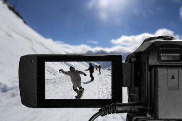 Nahaufnahme von einem Camcorder bei Videoaufnahmen in einem Skigebiet (Composing)