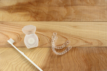 Toothbrush, mouthpiece and dental floss on a wooden table - obrazy, fototapety, plakaty