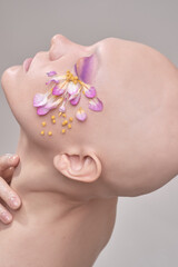 A beautiful woman without hair with flowers on her head, a conceptual photo with an unusual model