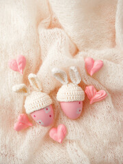 Happy Easter holiday concept with cute handmade eggs, knitted bunny hats and sweet pink decor, copy space. Greeting card, banner for your site, flyer, banner, invitation, discount card