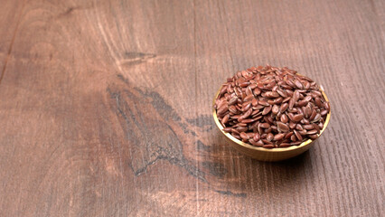 Brown flax seed or linseed on wooden background. Diet healthcare healthy food.
