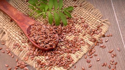 Brown flax seed or linseed on wooden background. Diet healthcare healthy food.
