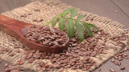 Brown flax seed or linseed on wooden background. Diet healthcare healthy food.