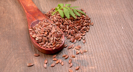 Brown flax seed or linseed on wooden background. Diet healthcare healthy food.