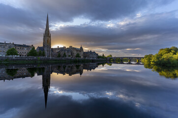 Fototapeta na wymiar Beautiful sunset at St Matthew's Church on River Tay with reflection , Perth , Scotland