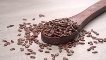 Brown flax seed or linseed on wooden background. Diet healthcare healthy food.