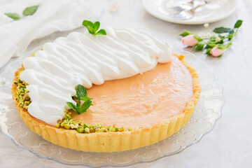 Obraz na płótnie Canvas Grapefruit tart with whipped cream and pistachios on marble background.