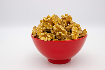 Peeled walnuts in red plate